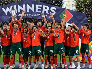 Para pemain Portugal Cristiano Ronaldo mengangkat trofi UEFA Nations League 2025 setelah memenangkan pertandingan melawan Spanyol di Allianz Stadium, Jerman pada 8 Juni 2025 atau Senin (9/6/2025) dini hari WIB. (John MACDOUGALL/AFP)