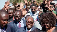 Mantan Presiden Zimbabwe, Robert Mugabe tiba untuk memberikan suara dalam pemilihan umum negara itu di TPS distrik Highfield, Harare, Senin (30/7). Mugabe memberikan suara di sebuah sekolah ditemani oleh istrinya, Grace. (AFP/Zinyange AUNTONY)