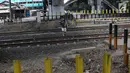 Seorang siswa menyeberangi perlintasan kereta api di Tanjung Barat, Jakarta, Senin (7/1). Meskipun sering terjadi kecelakaan dan dipasangi pagar, pejalan kaki tetap melompati pagar dari pada menggunakan fasilitas JPO. (Liputan6.com/Immanuel Antonius )