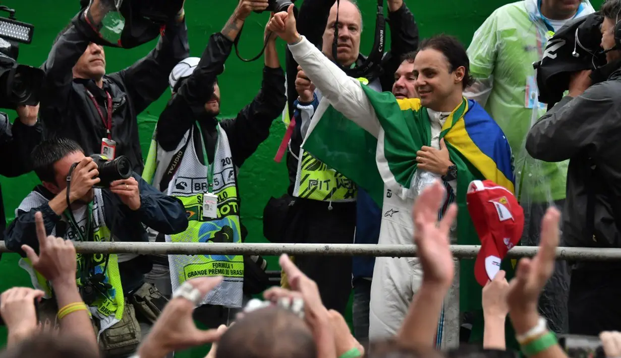 Pebalap Williams asal Brasil, Felipe Massa, menyapa pendukungnya. Ini adalah balapan F1 terakhir Massa di negaranya karena musim depan sudah pensiun dari arena F1. (AFP/Nelson Almeida)