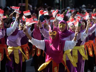 Sejumlah peserta membawa bendera merah putih saat mengikuti pawai pembangunan melintasi Jalan Malioboro, Yogyakarta, Minggu, (20/8. Pawai pembagunan diselenggarakan di tiap tiap daerah setiap tahun setelah peringatan HUT RI. (Liputan6.com/Boy Harjanto)