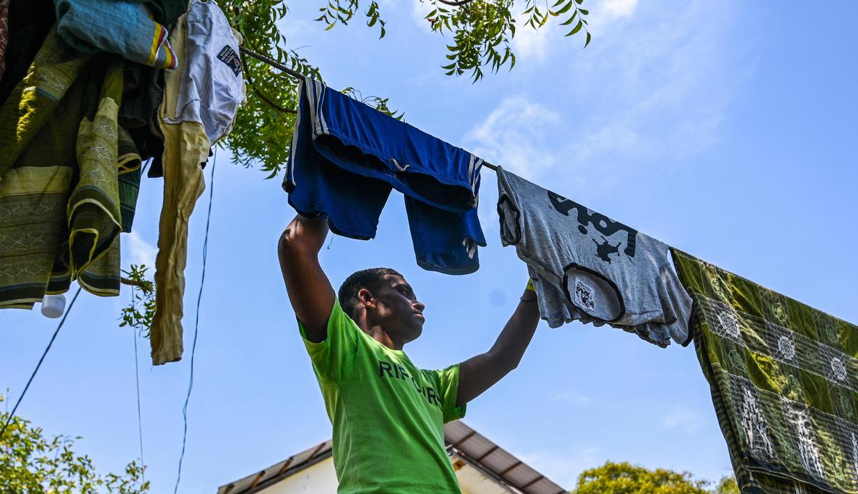 Seorang pengungsi Rohingya menerima potongan rambut di tempat penampungan sementara di Ladong, provinsi Aceh, Jumat 24 Februari 2023. Sedikitnya 69 pengungsi Rohingya mendarat di pantai barat Indonesia pada 16 Februari lalu dengan sebuah perahu kayu, kata seorang pejabat badan pengungsi PBB. (CHAIDEER MAHYUDDIN/AFP)
