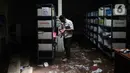Petugas memeriksa berkas-berkas saat membersihkan ruangan di MTsN 19 Pondok Labu, Jakarta, Jumat (7/10/2022). Petugas PPSU, Satpol PP, dan Dinas Pemadam Kebakaran membersihkan ruang kelas, kantin, dan fasilitas lainnya usai terendam banjir pada Kamis sore kemarin. (Liputan6.com/Herman Zakharia)