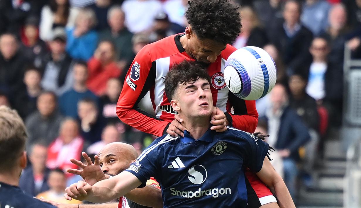 Pemain Manchester United, Tyler Fredricson (bawah) berduel udara dengan pemain Brentford, Kevin Schade dalam laga lanjutan Liga Inggris 2024/2025 di Gtech Community Stadium, London, Inggris, Minggu (04/05/2025) waktu setempat. (AFP/Justin Tallis)