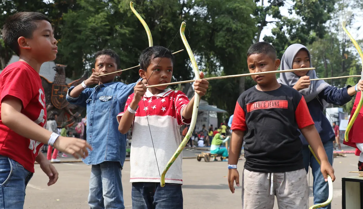 Anak-anak mengikuti permainan tradisional pada Pekan Kebudayaan Nasional di Istora Senayan, Jakarta, Sabtu (12/10/2019). Perhelatan itu dimeriahkan kompetisi olahraga tradisional berupa permainan rakyat seperti egrang, lari balok, terompah panjang, dan hadang.. (Liputan6.com/Angga Yuniar)