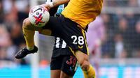 Pemain Newcastle United Bruno Guimaraes (kiri) bertarung memperebutkan bola dengan pemain Wolverhampton Wanderers Joao Moutinho pada pertandingan sepak bola Liga Inggris di St. James' Park, Newcastle, Inggris, 12 Maret 2023. Newcastle United mengalahan Wolverhampton Wanderers dengan skor 2-1. (Owen Humphreys/PA via AP)