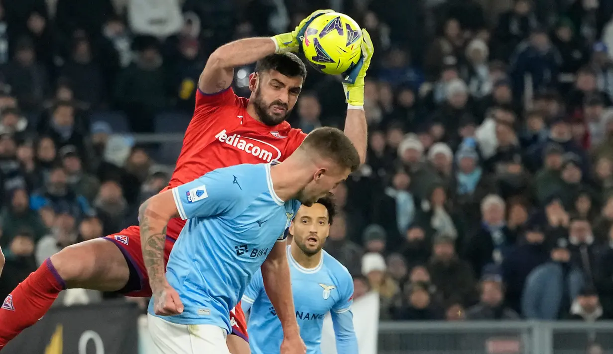Kiper Fiorentina Pietro Terracciano (atas) melakukan penyelamatan bola dari pemain Lazio Sergej Milinkovic-Savic pada pertandingan sepak bola Liga Italia di Olympic Stadium, Roma, Italia, 29 Januari 2023. Lazio ditahan imbang 1-1 oleh Fiorentina. (AP Photo/Alessandra Tarantino)
