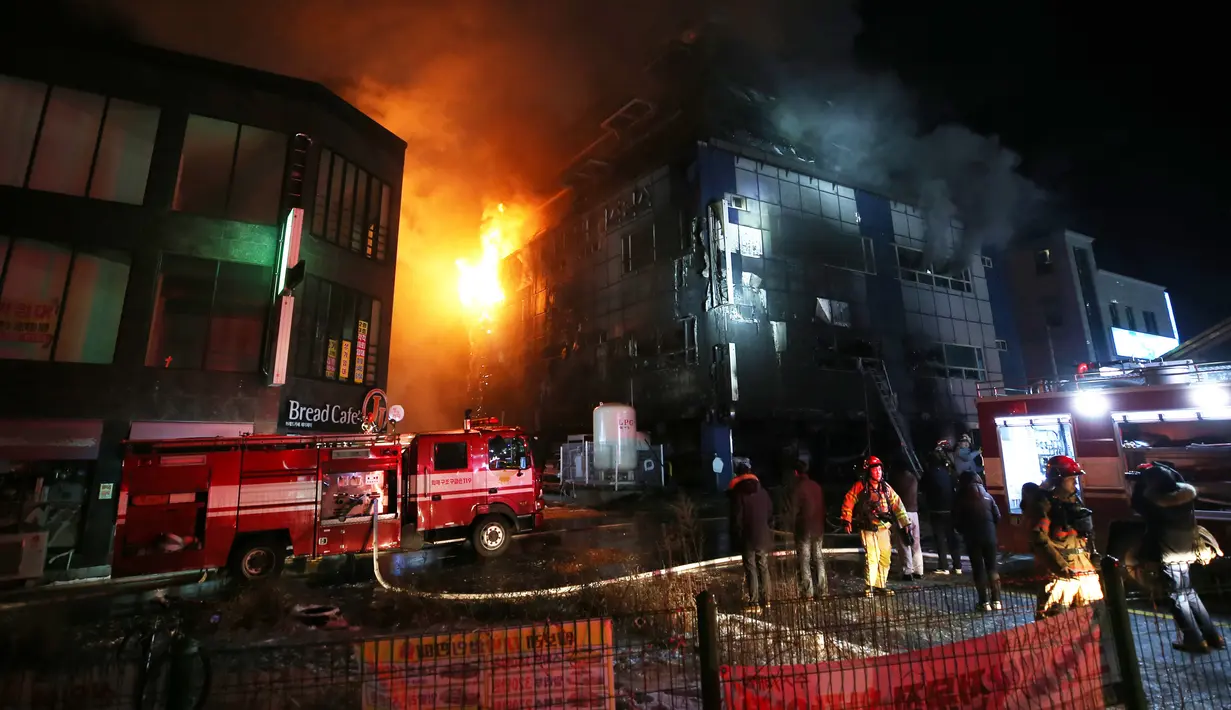 Petugas pemadam kebakaran berusaha memadamkan api yang melahap sebuah pusat kebugaran di kota Jecheon, Korea Selatan (Korsel), Kamis (21/12). Kebakaran besar itu menewaskan 29 orang dan menyebabkan puluhan lain terluka. (Kim Hyung-woo/Yonhap via AP)
