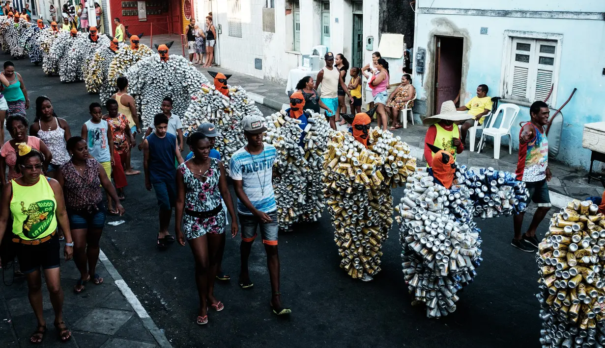 Selain menggunakan kostum kaleng, peserta karnaval menggunakan topeng oranye untuk parade Bloco Da Latinha di Madre de Deus, Brasil (9/2/2016). Setiap kostum kaleng yang dipakai Bloco Da Latinha memiliki berat sekitar 11-15 kg. (AFP Photo/Yasuyoshi Chiba)