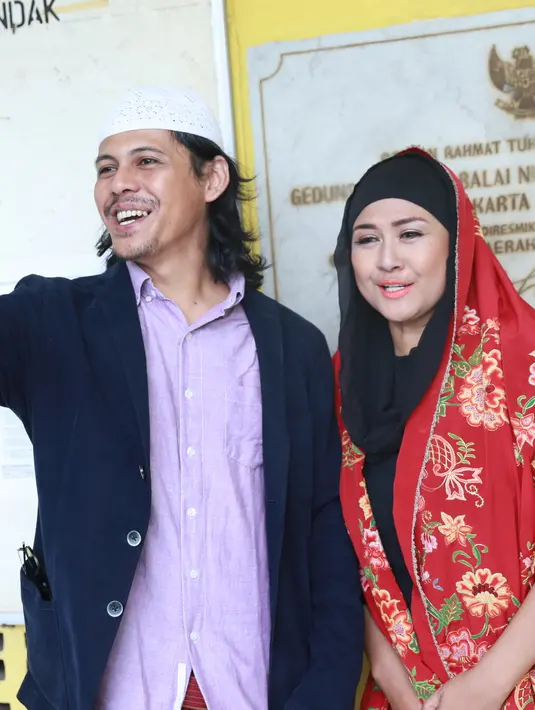 Pada akad nikah itu, kedua pasangan ini mengenakan busana sederhana. Ria tampil cantik dengan mengenakan busana hitam padanan songket. Sedangkan mempelai pria mengenakan jas, dengan bawahan kain sarung plus peci putih. (Adrian Putra/Bintang.com)