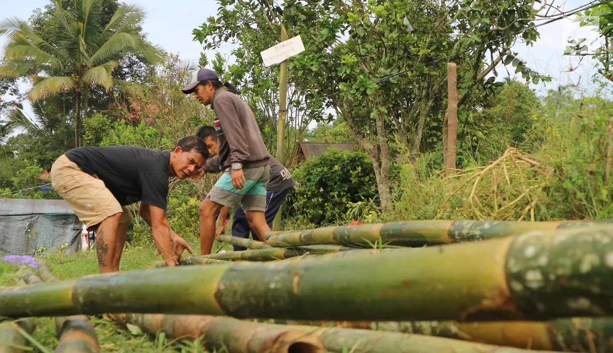 Warga menata bambu untuk membangun kamp pengungsian Gunung Agung di lahan milik dinas pertanian, Karangasem, Bali, Senin (27/11). BNPB mengatakan ada 22 desa yang warganya harus mengungsi terkait status awas Gunung Agung. (Liputan6.com/Andi Jatmiko)