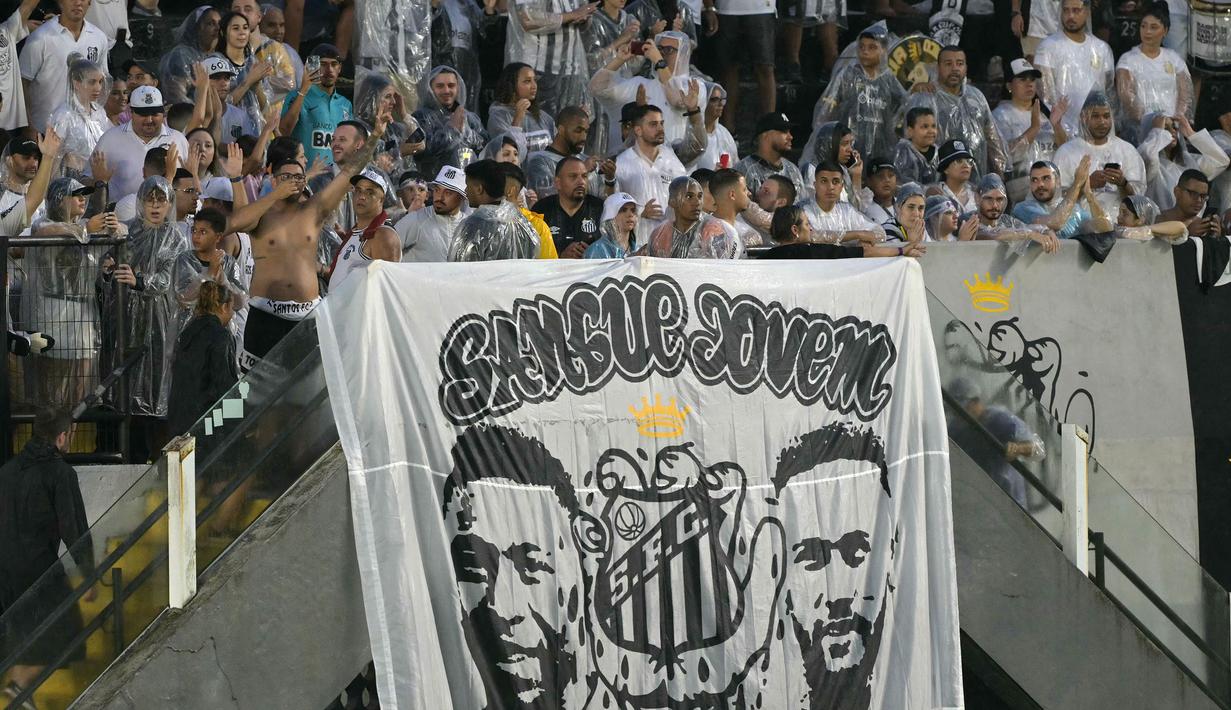 Pendukung Santos membentangkan banner bergambar legenda Brasil, Pele dan Neymar saat pengenalan pemain baru Santos, Neymar di Vila Belmiro, Sao Paulo, Brasil, Sabtu (01/02/2025) WIB. (AFP/Nelson Almeida)