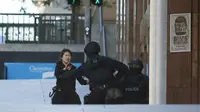 Seorang sandera langsung diamankan petugas kepolisian setelah berhasil keluar dari Kafe Lindt, Martin Place, Sydney, Senin (15/12/2014). (REUTERS/Jason Reed)