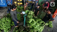 Pedagang tengah menurunkan pisang yang akan di jual di Pasar Lembang, Kota Tangerang, Kamis (28/3/2024). (Liputan6.com/Angga Yuniar)