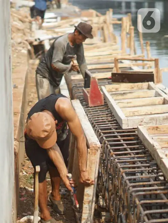 Pekerja menyelesaikan pembuatan turap Kali Ancol di Jakarta Utara, Minggu (15/12/2019). Dinas Sumber Daya Air Pemprov DKI melakukan penataan turap Kali Ancol sebagai bagian dari program pengendali banjir yang nantinya juga akan digunakan sebagai jalur pedestrian. (Liputan6.com/Immanuel Antonius)