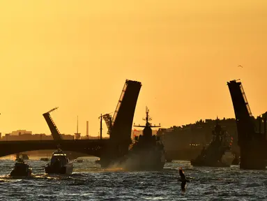 Kapal perang Rusia berlayar di sungai Neva melalui jembatan gantung selama latihan parade Angkatan Laut di Saint Petersburg pada awal 16 Juli 2023. (AFP/Olga Maltseva)