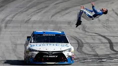 Pembalap Carl Edwards melakukan aksi gila dengan salto dari mobil ketika mesin dalam keadaan berjalan perlahan usai merayakan kemenangan NASCAR Sprint Cup Series Food City 500 di Bristol Motor Speedway (17/4). (AFP/Matt Sullivan)