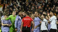Wasit Spanyol Jesus Gil Manzano (belakang) berbicara dengan gelandang Inggris Real Madrid #5 Jude Bellingham selama pertandingan sepak bola liga Spanyol antara Valencia CF dan Real Madrid di Stadion Mestalla, Valencia pada Minggu (3/3/2024). (JOSE JORDAN / AFP)