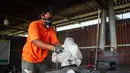 Pekerja memasukkan kantong plastik ke dalam mesin pengolah untuk memproduksi Petasol dalam sebuah lokakarya di Pekanbaru, Riau, pada 8 Agustus 2025. (Wahyudi/AFP)