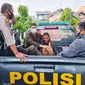 Pelaku penyerangan imam masjid di Pekanbaru dijemput personel Polsek Tampan. (Liputan6.com/M Syukur)