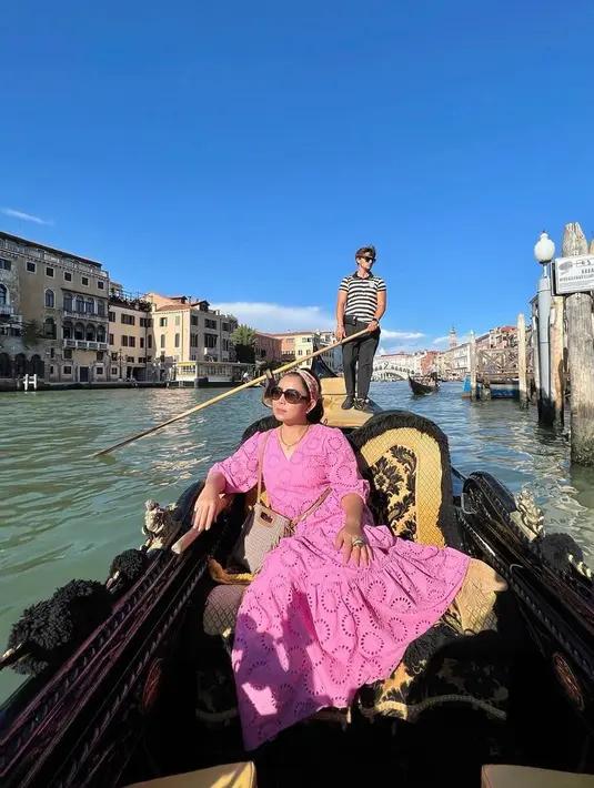 Seperti saat naik gondola ini, ia tampil fresh dengan dress pink, dipadu dengan mini bag, dan bando.