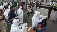Paramedis mengambil sampel penumpang KRL Commuter Line saat tes swab di Stasiun Bojonggeder, Jawa Barat, Senin (11/05/2020).  Tes swab dan rapid dilakaukan sebagai salah satu metode untuk mendeteksi dan mencegah penyebaran Covid-19 di moda transportasi KRL Commuter Line. (merdeka.com/Arie Basuki)