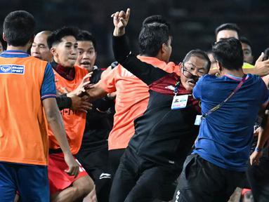 Manajer Timnas Indonesia U-22, Sumardji (tengah kiri) dikeroyok oleh official Timnas Thailand U-22 pada laga final SEA Games 2023 di Olympic Stadium, Phnom Penh, Kamboja, Selasa (16/05/2023). (AFP/Mohd Rasfan)