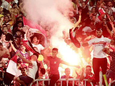 Para suporter Mesir menyalakan flare merayakan keberhasilan negaranya lolos ke Piala Dunia 2018 di Stadion Borg El Arab, Alexandria, Senin (8/10/2017). Mesir lolos ke Piala Dunia setelah absen sejak gelaran tahun 1990. (AP/Nariman El-Mofty)