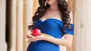 Wanita yang sedang hamil besar ini berpose memegang buah apel layaknya film Snow White atau Putri Salju. Dalam konsep pemotretan ini, Vic dan Marie menampilkan para ibu yang sedang hamil besar bak putri Disney. (Instagram/vicandmariephotography)