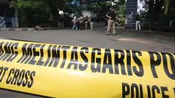 Petugas memasang garis polisi di TKP terjadinya teror di Cikokol, Tangerang, Banten, Kamis (20/10). Dalam aksi teror tersebut pelaku yang diduga simpatisan ISIS melakukan penusakan terhadap Kapolsek Tangerang. (Liputan6.com/Stringer)