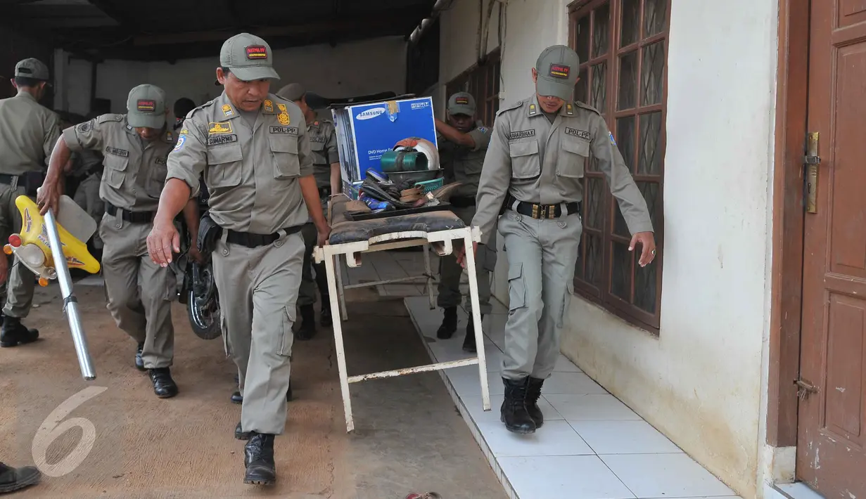 Petugas membantu warga untuk mengevakuasi barang saat pembongkaran bangunan di kawasan Pangkalan Jati, Bekasi, Jawa Barat, Kamis (8/10). Pembongkaran dilakukan untuk mempersiapkan lahan pembangunan Jalan Tol  Becakayu. (Liputan6.com/Gempur M Surya)