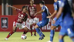 Gelandang Bali United, Hariono (kiri) berusaha melewati hadangan mantan rekannya di Persib Bandung, gelandang Esteban Vizcarra dalam laga Grup D Piala Menpora 2021 di Stadion Maguwoharjo, Sleman. Rabu (24/3/2021). Bali United bermain Imbang 1-1 dengan Persib. (Bola.com/Arief Bagus)