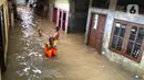 Anak-anak bermain di tengah banjir yang merendam kawasan Kebon Pala, Jakarta Timur, Selasa (25/2/2020). Akibat banjir yang tak kunjung surut, aktivitas warga di kawasan tersebut menjadi terganggu, terlebih dengan adanya pemadaman listrik. (Liputan6.com/Immanuel Antonius)