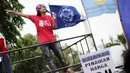 Seorang buruh wanita berorasi menuntut Jokowi untuk melindungi para buruh migran saat aksi di Istana Negara, Jakarta, Kamis (18/12/2014). (Liputan6.com/Faizal Fanani)