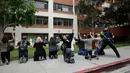 Petugas memeriksa sejumlah orang menyusul penembakan di Universitas California Los Angeles (UCLA), Rabu (1/6). Insiden itu memicu penutupan kampus dan memaksa ratusan mahasiswa yang ketakutan bersembunyi di dalam gedung. (REUTERS/Patrick T. Fallon)