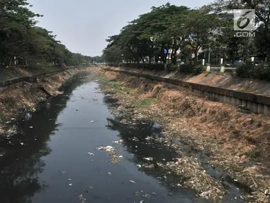 Tumpukkan sampah dan air yang berwarna hitam pekat memenuhi aliran Kanal Banjir Barat, Jakarta, Minggu (22/9/2019). Minimnya pengawasan Pemprov DKI menyebabkan aliran di sepanjang Kanal Banjir Barat menghitam dan penuh sampah hingga menimbulkan bau tak sedap. (merdeka.com/Iqbal S Nugroho)