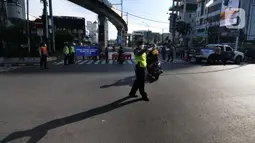 Polisi mengatur arus lalu lintas saat penyekatan masa PPKM Darurat di Perempatan Fatmawati, Jakarta, Senin (12/7/2021). Hanya dokter, paramedis, ambulans, darurat dan pengendara bermotor yang dapat menujukkan STRP yang boleh melintas. (merdeka.com/Arie Basuki)