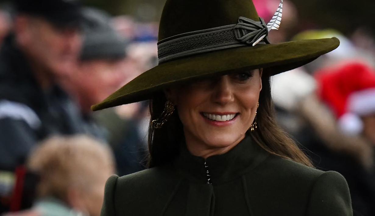Kate Middleton, Princess of Wales dari Inggris tersenyum saat tiba untuk kebaktian Natal di Sandringham, Norfolk, Inggris pada 25 Desember 2022. Ibu tiga anak ini tampak bergaya dalam balutan coat hijau olive panjang yang bagian bawahnya lebar dari koleksi Alexander McQueen. (AFP/Daniel Leal)