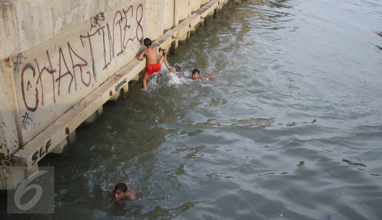Sejumlah anak bermain dan berenang di anak Kali Ciliwung, Jakarta, Rabu (13/7). Bersihnya kali yang berada di Ibu Kota itu dimanfaatkan anak-anak sekitar untuk berenang sambil mengisi waktu libur sekolah. (Liputan6.com/Immanuel Antonius)