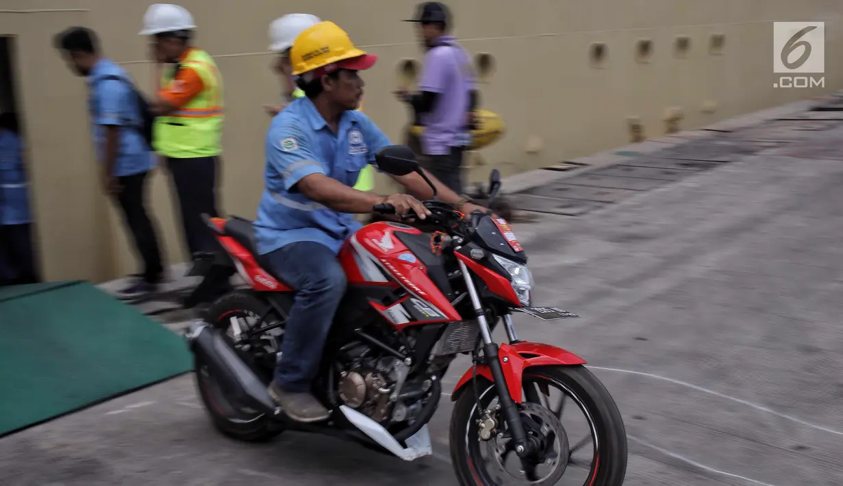Petugas membawa motor pemudik gratis di Pelabuhan Tanjung Priok, Jakarta, Rabu (20/6). Puncak arus balik pemudik di Pelabuhan tersebut diperkirakan akan terjadi H+7 Lebaran. (Liputan6.com/Faizal Fanani)