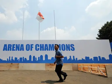 Seseorang melintas di depan banner arena champions di Istora Senayan, Jakarta, Jumat (7/8/2015). Jelang perhelatan Kejuaraan Bulutangkis Dunia 2015, sejumlah persiapan terus dilakukan pihak panitia pelaksana. (Liputan6.com/Helmi Fithriansyah)