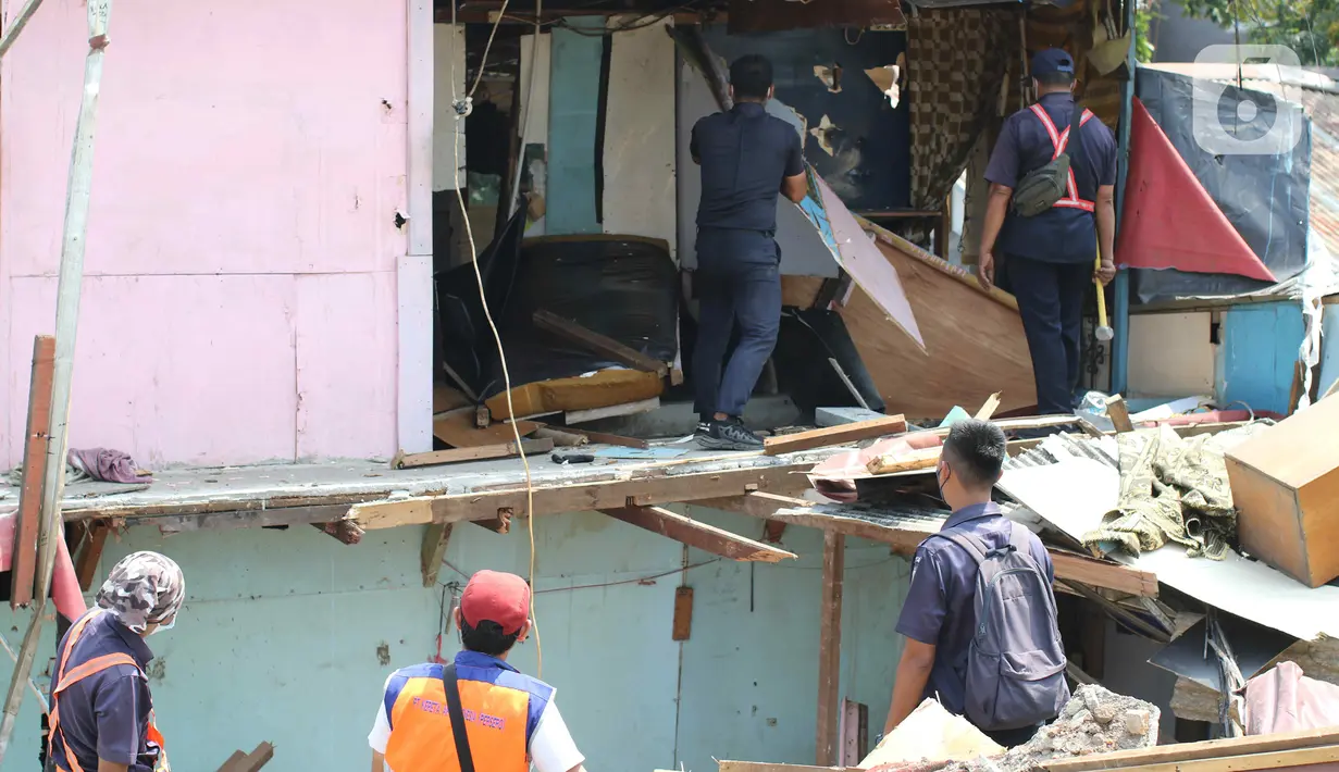 Sejumlah petugas gabungan dari Satpol PP, KAI dan Polisi membongkar bangunan lokalisasi liar Gunung Antang di Matraman, Jakarta Timur, Selasa (30/8/2022). Satu unit ekskavator diturunkan untuk membantu proses pembongkaran lokalisasi liar itu. (Liputan6.com/Herman Zakharia)