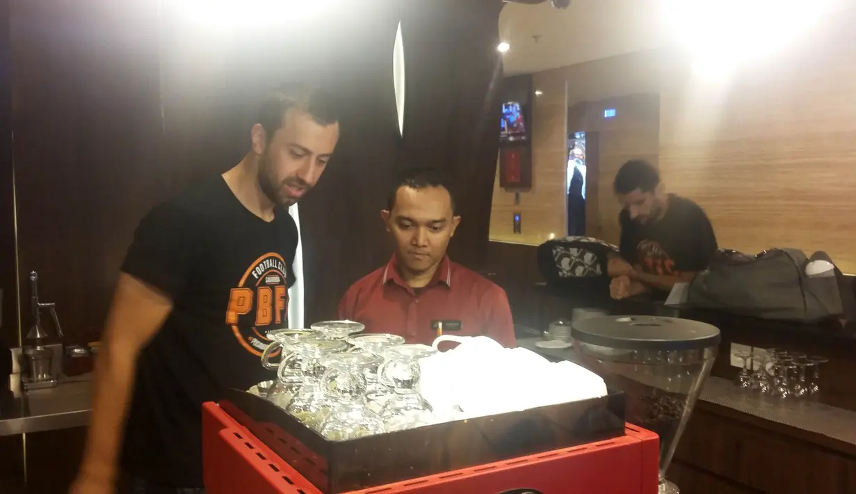 Pemain Pusamania Borneo FC, Goran Gancaev (kiri) belajar menjadi barista sebelum bertanding pada lanjutan Piala Jenderal Sudirman di Surabaya,Sabtu (21/11/2015). (Bola.com/Vitalis Yogi Trisna)