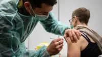 Tentara Swiss memberikan suntikan vaksin booster COVID-19 Moderna di Delemont, Swiss, 14 Desember 2021. Swiss yang dilanda gelombang infeksi baru COVID-19 telah memanggil tentara untuk mempercepat vaksinasi.
(Fabrice COFFRINI/AFP)