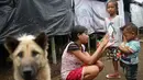 Anak-anak bermain di sekitar tenda Posko Pengungsi Rendang, Bali, Sabtu (2/12). Erupsi Gunung Agung membuat anak-anak tersebut terpaksa harus bermain di posko pengungsian dengan kondisi yang seadanya. (Liputan6.com/Immanuel Antonius)