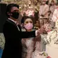 Pengantin memakai masker saat simulasi penerapan protokol kesehatan resepsi pernikahan di era new normal di Jakarta, Kamis (9/7/2020). Kegiatan ini bertujuan untuk mengedukasi masyarakat dalam acara pernikahan guna mencegah penyebaran COVID-19. (Liputan6.com/Faizal Fanani)