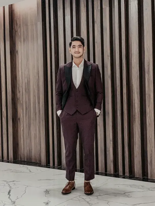 Pria berusia 29 tahun tersebut tampil memesona dengan setelan jas berwarna ungu tua dengan inner kemeja putih. Penampilannya semakin emnarik dengan sepatu dengan warna senada. (Liputan6.com/IG/arya.saloka)
