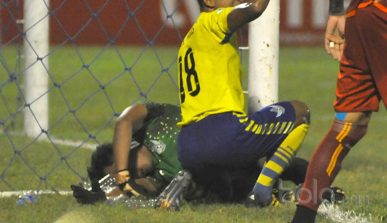 Aji Saka tergeletak dilapanagan usai menghantam tiang gawang sebelah kanan saat melawan Arema FC pada Liga 1 2017 di Gresik, (12/7/2017). (Bola.com/Fahrizal Anas). 
