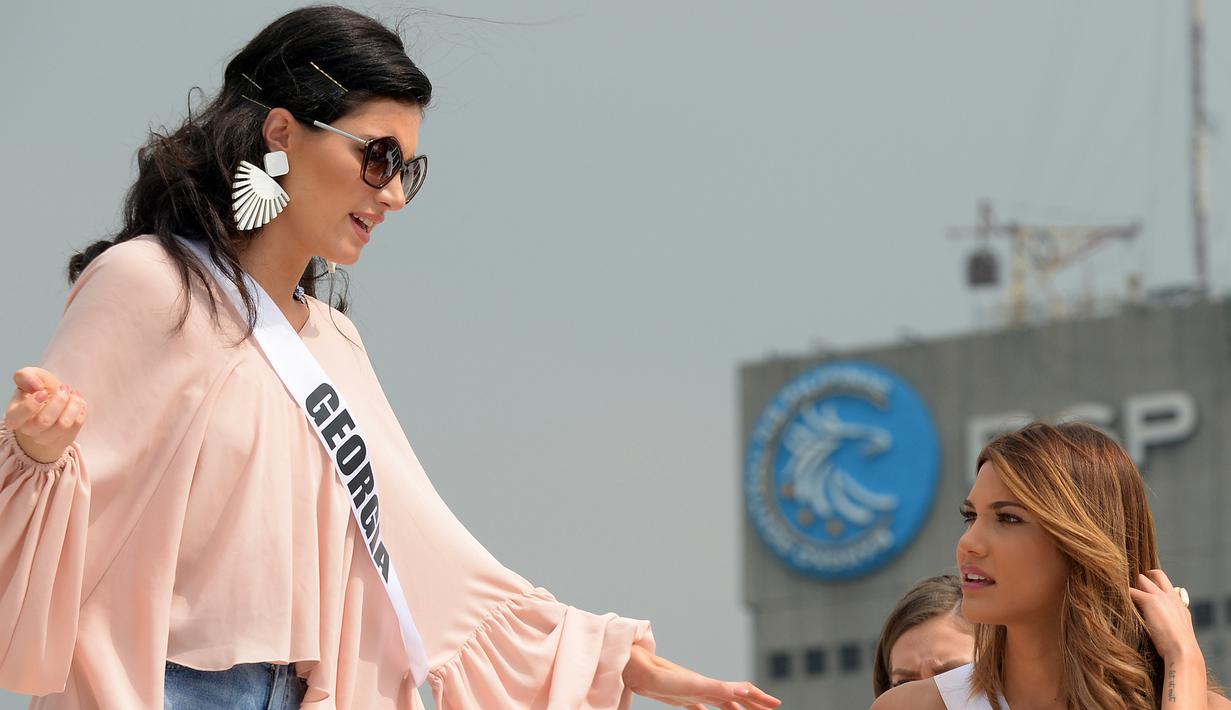 Kontestan asal Georgia, Nuka Karashvili (kiri) berbincang dengan kontestan asal Panama, Keity Drennan saat berada di atas kapal pesiar saat bertamasya ke sebuah resor wisata pantai di Manila, Filipina (19/1). (AFP Photo/Ted Aljibe)