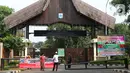 Petugas pengelola memasang spanduk pemberitahuan penutupan Kawasan Wisata Perkampungan Budaya Betawi Setu Babakan, Jakarta, Sabtu (14/3/2020). Hal ini menyusul instruksi Gubernur DKI Jakarta yang menutup sejumlah lokasi wisata selama 14 hari kedepan. (Liputan6.com/Helmi Fithriansyah)
